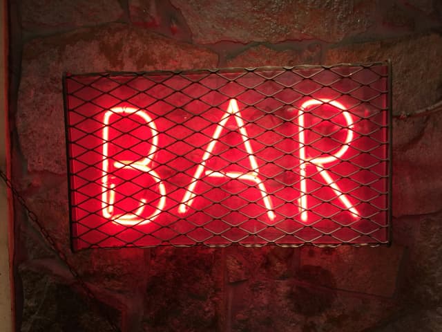 A wall with a neon sign reading 'Bar'